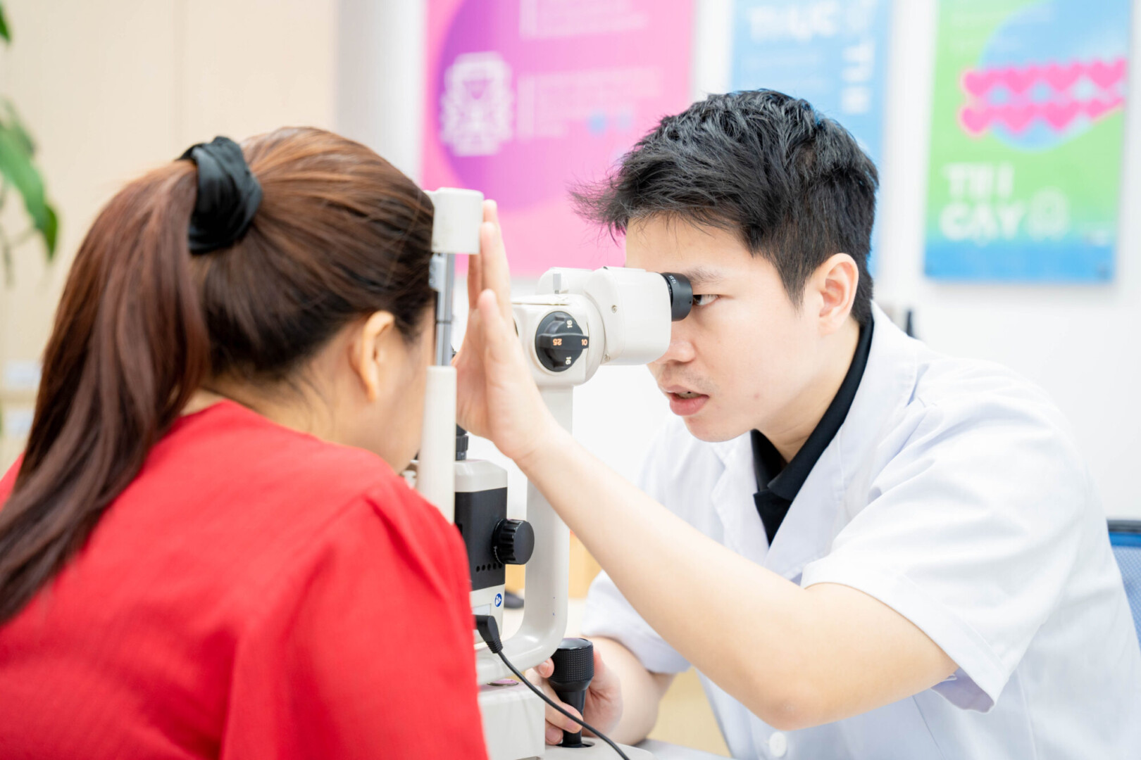 Bác sĩ chuyên khoa Bệnh viện Mắt Ánh Dương tận tình khám và kiểm tra mắt bằng máy sinh hiển vi cho người dân.